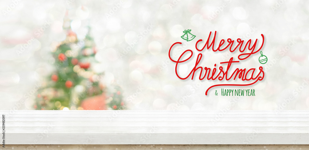 Poster merry christmas and happy new year at white wood table top at blur bokeh christmas tree decor with s
