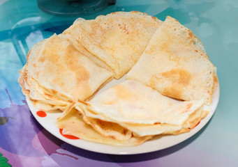 Cooked pancakes for Breakfast rolled on a plate