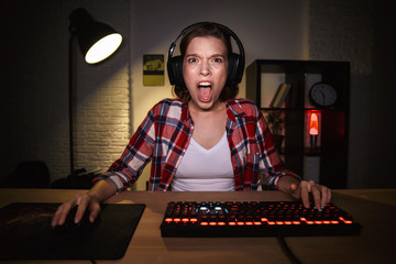 Shocked girl gamer sitting at the table © Drobot Dean
