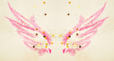 Golden glitter and glittering stars on abstract pink watercolor wings in vintage nostalgic colors.