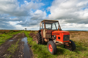 old rusty tractor in a peat bog landscape, rural Ireland 