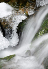 Waterfall with ice crystals forming on a winter mountain creek.