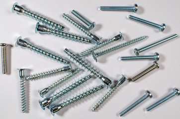 White metal screws and screws on white background