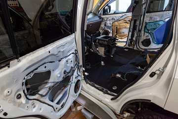 The back of the SUV, disassembled elements of the car's interior in a white crossover, removed the side door trim, removed the seat, installed insulation inside.