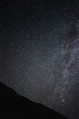 night sky full of stars over mountains, shooting star and milky way