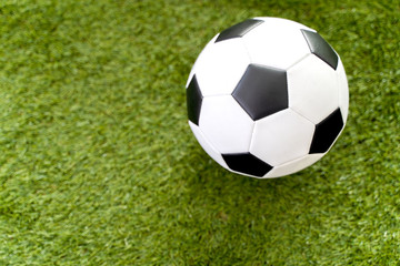 Football ball on green grass field background.