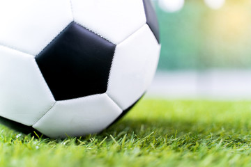 Fototapeta na wymiar Football ball on green grass field background.