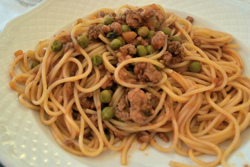 Spaghetti con ragù di carne, salsiccia e piselli