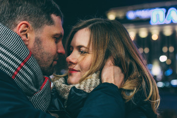 Real young couple walking together in night city, kissing and sm