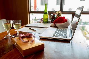 Christmas equipment with santa hat on office table in last working day. Young creative people are celebrating holiday in modern office. Merry Christmas and Happy New Year.