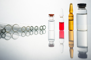 Group of vials with medication on blue methacrylate table.