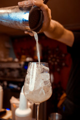 Bartender is stirring cocktails on the bar counter