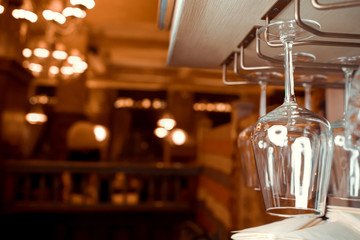 Clean wine glasses above a bar rack in a nightclub.
