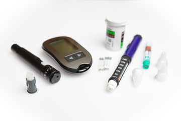 Diabetic set of lancet with spare needles, glucometer, strips, box of spare strips, pen injector, spare insulin and pen needles isolated on white background