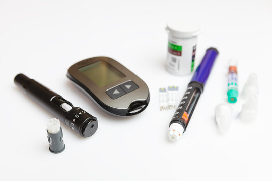 Diabetic set of lancet with spare needles, glucometer, strips, box of spare strips, pen injector, spare insulin and pen needles isolated on white background