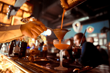 Bartender is stirring cocktails on the bar counter