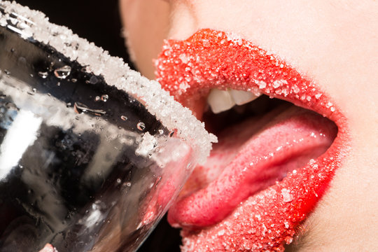 Cocktail bar. Sugar on women's lips. Sweet drink. Sweet kiss. Woman drinking alcohol with sugar. Seductive sensual tongue in the mouth. Christmas adult party.