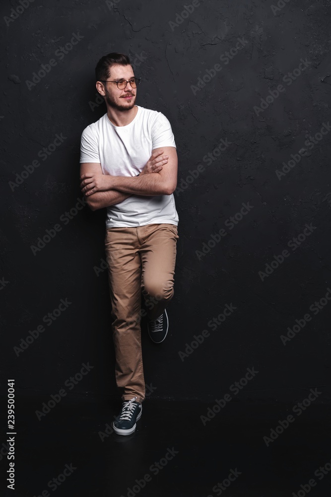 Wall mural Full length portrait of happy handsome young man isolated on black background.