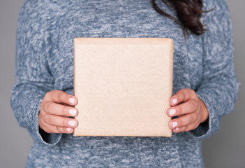 Woman holding blank carton box. Mockup for design