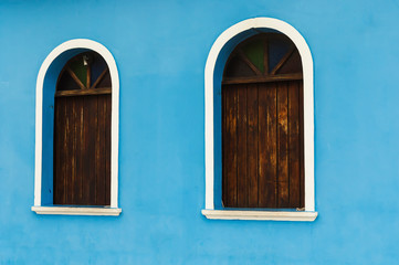 old wooden brown windows on a blue wall