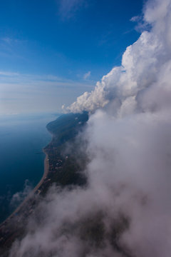 flight near the wall of clouds, free flight. Wall of clouds, blue sky and sea.