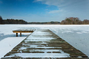 Wooden pier on frozen lake in north Poland