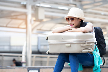 Asian girls are planning and waiting friends to travel on a summer vacation. They were excited and glad to have found a new place. Soft focus and blur.