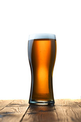 Frosty glass of light beer on wood table