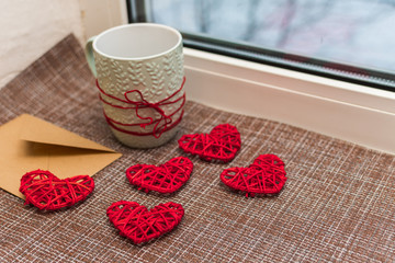 Cup, Kraft envelope and hearts on the windowsill. concept of Valentine's day