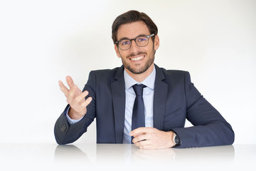 Isolated attractive businessman sitting at desk in suit