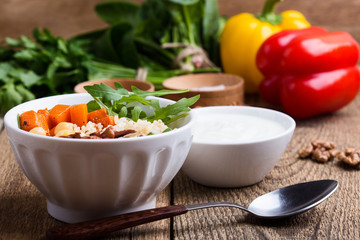 Healthy salad bowl with baked pumpkin,  chickpeas, quinoa, arugula, walnuts