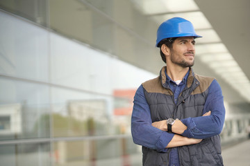 Industrial worker in hardhat infront of modern building