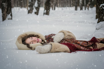Happy girl lie around in soft snow on a winter day