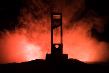 Horror view of Guillotine. Close-up of a guillotine on a dark foggy background.