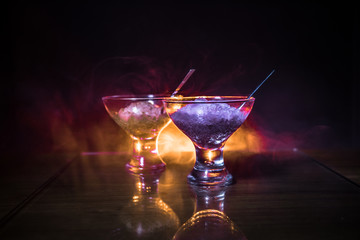 Glass filled with colorful fruit ice cream on dark background with toned light and fog