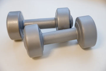 Fototapeta na wymiar Grey dumbbells isolated with clipping path.Shaping and fitness equipment.Barbells in small size, close up. Healthy shape and sport concept.Physical therapy for the elderly