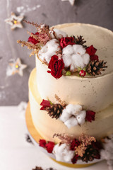 Fototapeta na wymiar Christmas cake with flowers and chocolate. Wedding details - wedding cake. Winter cake with cones