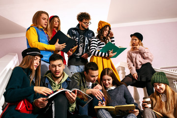 The group of cheerful students sitting in a lecture hall before lesson. The education, university, lecture, people, institute, college, studying, friendship and communication concept