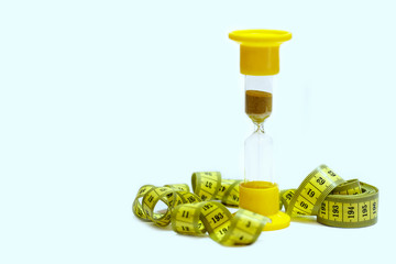 measuring tape and hourglass on white background