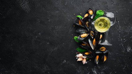 A bottle of white wine and mussels. Top view. Free space for your text. On the old background.