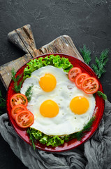 Eggs with tomatoes and fresh vegetables. Breakfast. Top view. Free space for your text.