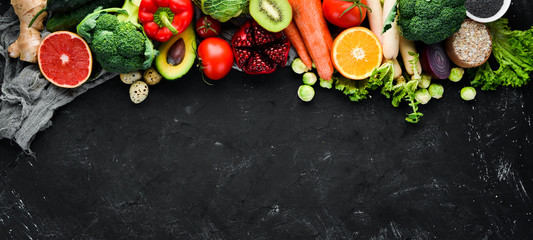 Organic food on a black stone background. Vegetables and fruits. Top view. Free copy space.