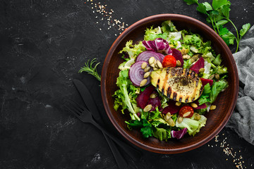 Salad. Lettuce, beets, avocados and pumpkin seeds. Top view. On a black background. Free copy space.