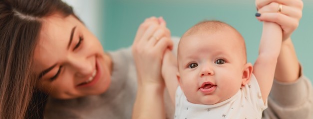 mother and her baby. A beautiful woman with dark hair and attractive facial features holds on her...