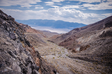 Fototapeta premium Valley and a desert wash filled with rocks, sand and sagebrush in Death Valley National Park in California