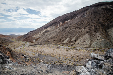 Valley and a desert wash filled with rocks, sand and sagebrush in Death Valley National Park in California