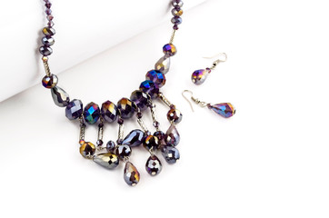 Obraz premium Faceted beads necklace with earrings on white background