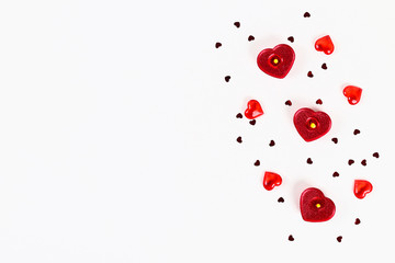 Valentine day layout. Pink gift with hearts, candles and confetti on a white background. St. Valentines Day, day love, February 14 concept. Copy space, top view, flat lay composition.