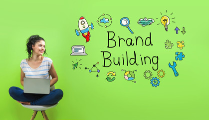 Brand building with young woman using a laptop computer  - obrazy, fototapety, plakaty