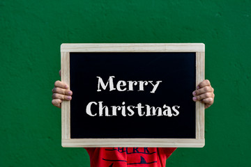 Merry Christmas written blackboard by a children